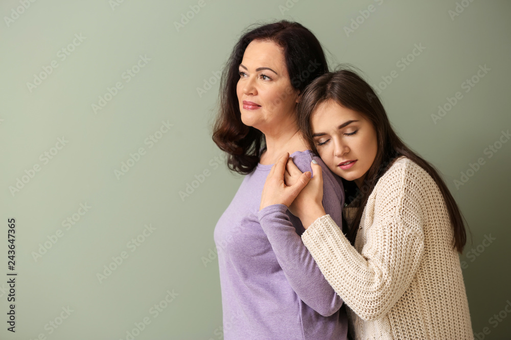 Portrait of young woman with her mother on color background Portrait of young woman with her mother on color background