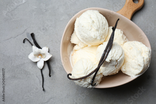 Bowl with tasty vanilla ice-cream on table