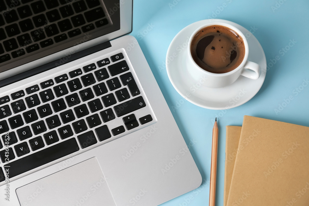 Modern laptop, cup of coffee and notebook on color background Modern laptop, cup of coffee and notebook on color background