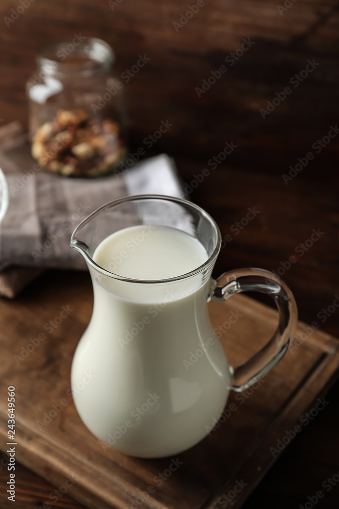 Jug of fresh milk on table