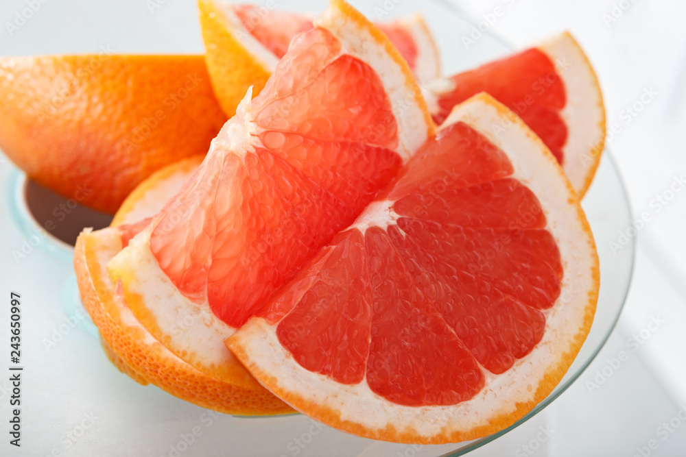 Ripe grapefruit slices in a juicer in the kitchen. Ripe grapefruit slices in a juicer in the kitchen.