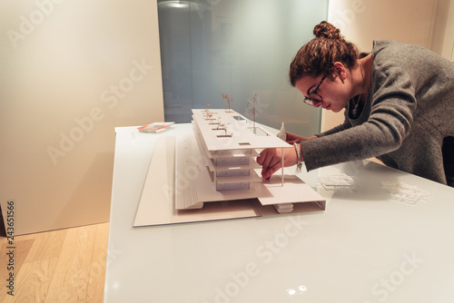 Female architect working on architecture model on table