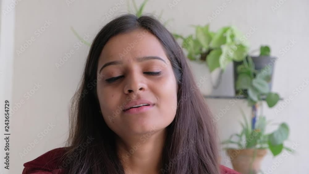 Smiling female hears a joke and starts smiling wide showing her perfect denture teeth Indian Smiling female hears a joke and starts smiling wide showing her perfect denture teeth Indian