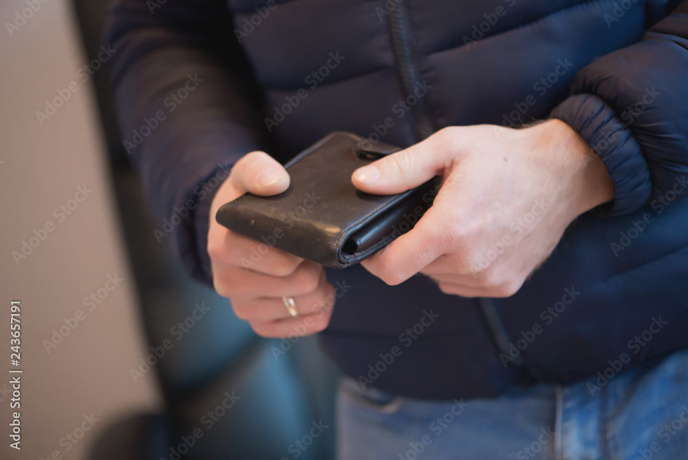 Businessman hands holding black wallet with coins money