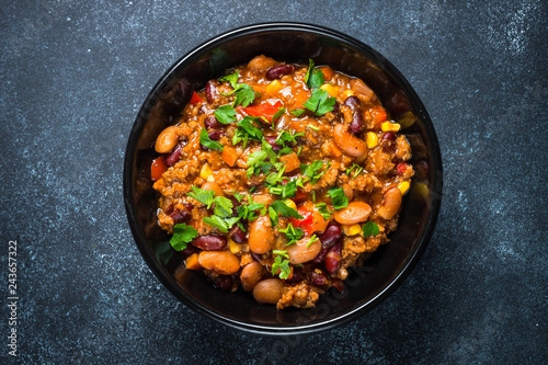 Chili con carne from meat and vegetables on black table top view