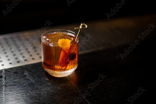 Glass of a Old Fashioned cocktail on the wooden steel bar counter photo