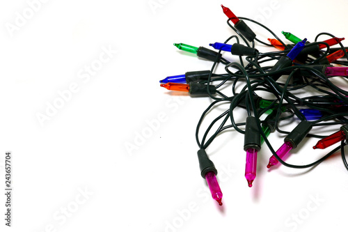 Multi-colored blinking light bulbs with coiled cables placed on a white background