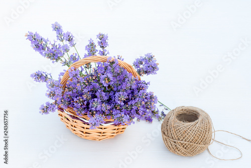 Fototapeta Naklejka Na Ścianę i Meble -  Fresh lavender in brown basket and hemp ball on white wooden background.