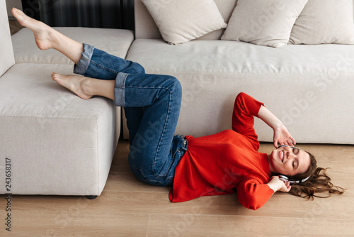 Cheerful young casually dressed woman laying on a floor