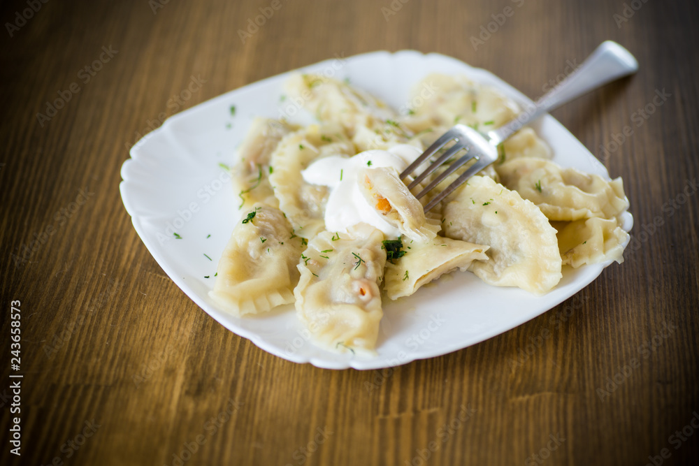 Dumplings boiled with stuffing on a wooden table Dumplings boiled with stuffing on a wooden table