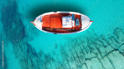 Aerial drone bird's eye top view of colourful traditional fishing boat in turquoise clear waters, Aegean sea, Greece © aerial-drone