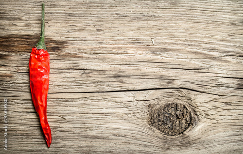 Hot chili pepper on wooden background.
