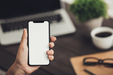 Hand holding smartphone with big blank screen