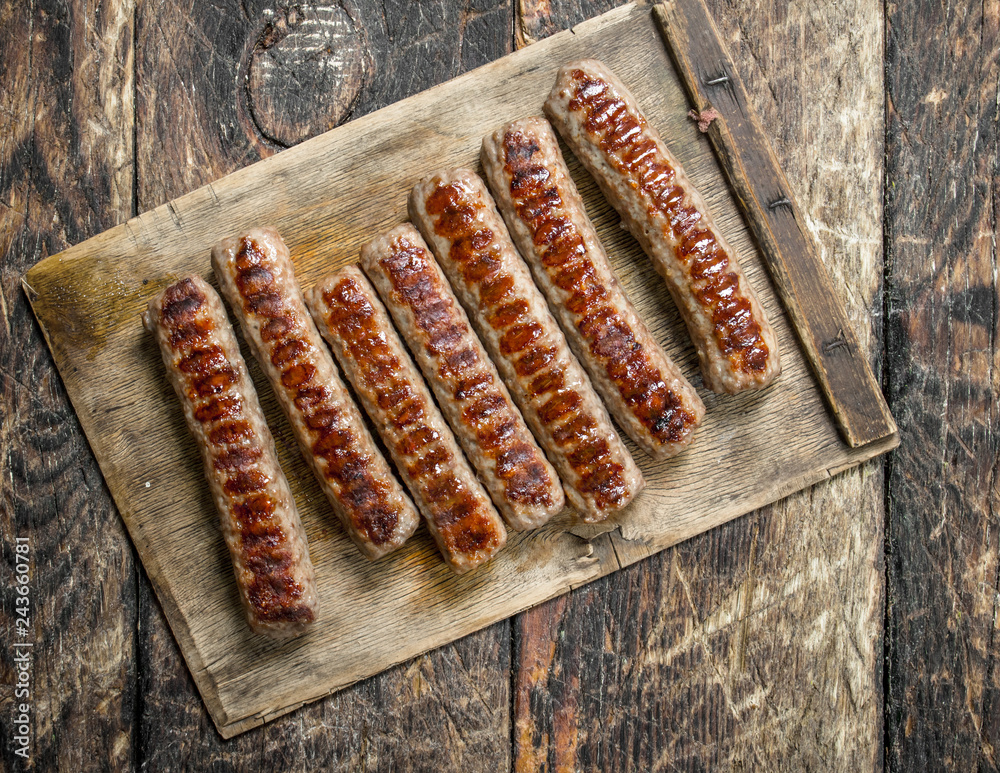 Grilled sausages on wooden table.
