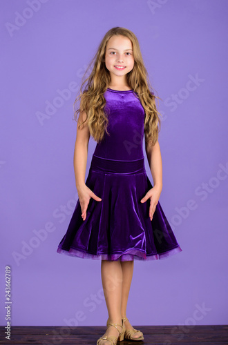 Kid fashionable dress looks adorable. Ballroom dancewear fashion concept. Kid dancer satisfied with concert outfit. Girl cute child wear velvet violet dress. Clothes for ballroom dance. Kids fashion