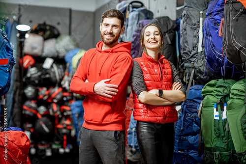Fototapeta Naklejka Na Ścianę i Meble -  Portrait of a smiling man and woman as a sellers or clients in the shop with sports equipment