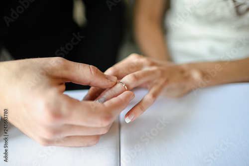 the groom wears an engagement ring to the bride