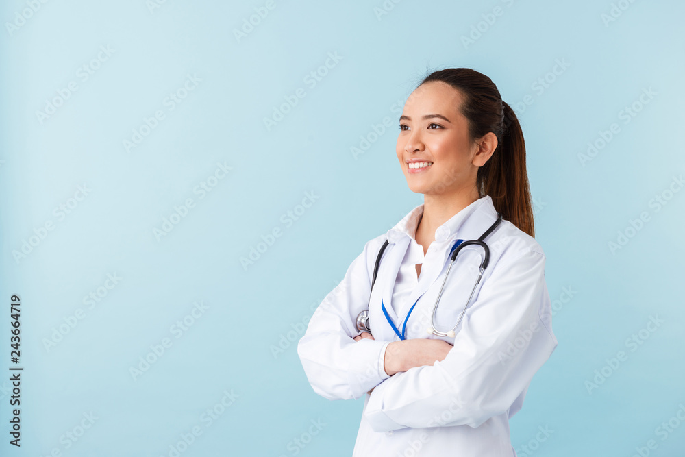 Woman doctor posing isolated over blue wall background with stethoscope.