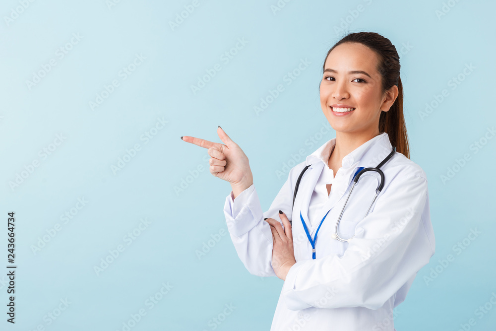 Woman doctor posing isolated over blue wall background with stethoscope. Woman doctor posing isolated over blue wall background with stethoscope.