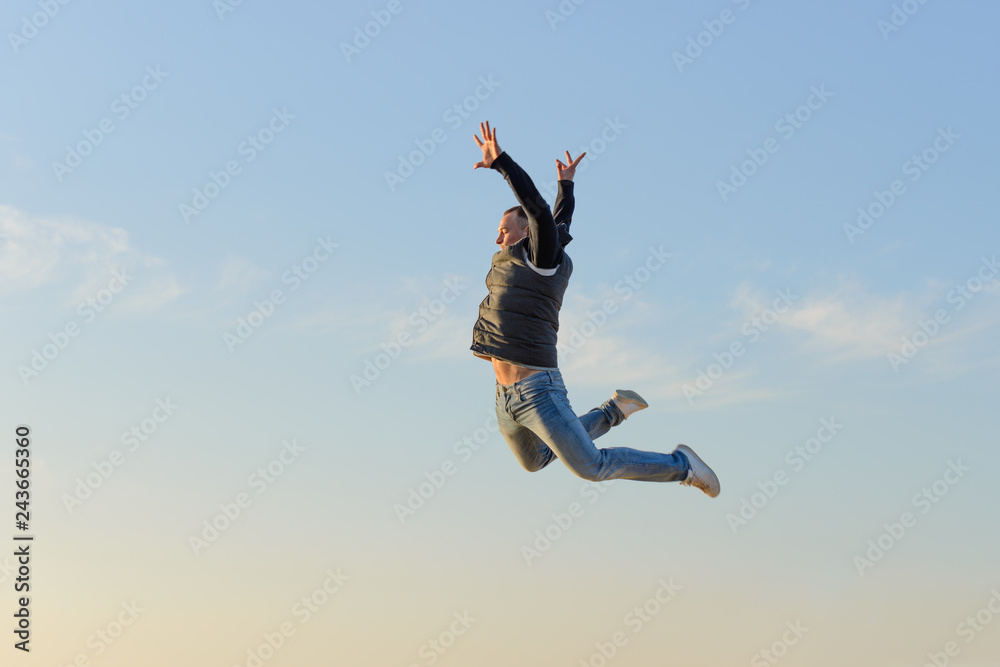 young man in a jump against a blue sky young man in a jump against a blue sky