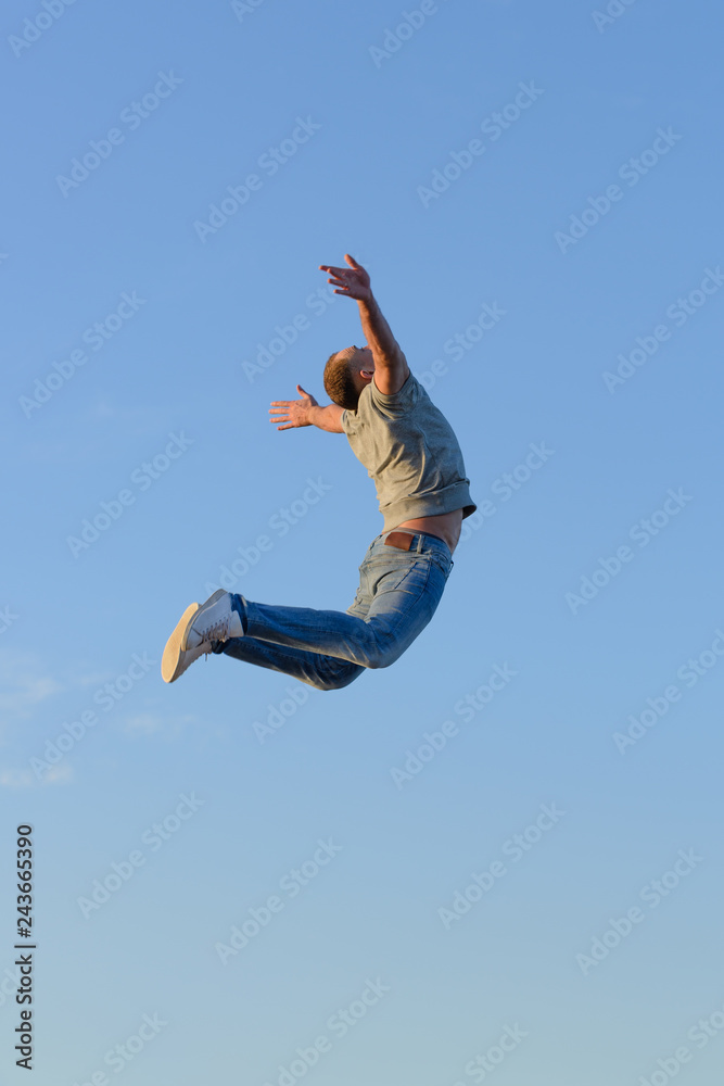 young man in a jump against a blue sky young man in a jump against a blue sky