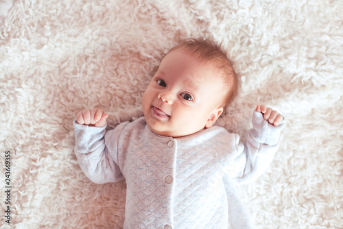 Funny baby lying in bed looking at camera. Childhood. Good morning.