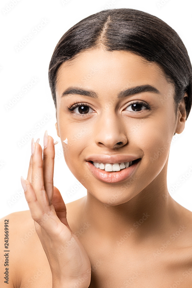 close-up view of beautiful young african american woman applying face cream and smiling at camera isolated on white close-up view of beautiful young african american woman applying face cream and smiling at camera isolated on white