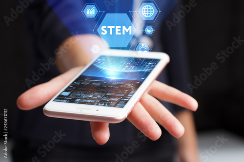 The concept of business, technology, the Internet and the network. A young entrepreneur working on a virtual screen of the future and sees the inscription: STEM