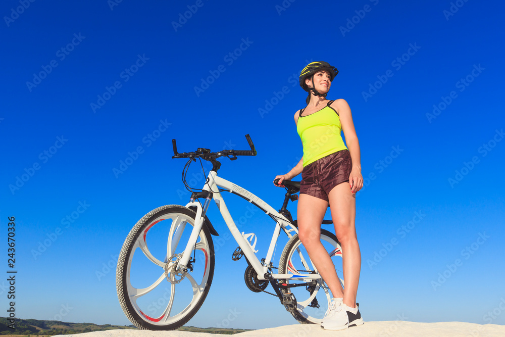 Young beautiful woman with a sport bike, soft focus background