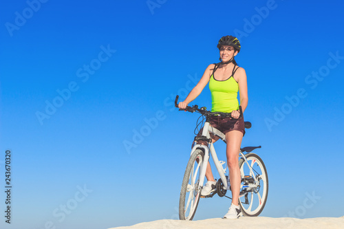 Young beautiful woman with a sport bike, soft focus background