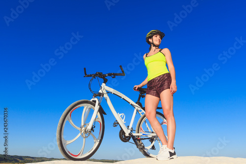 Fototapeta Naklejka Na Ścianę i Meble -  Young beautiful woman with a sport bike, soft focus background