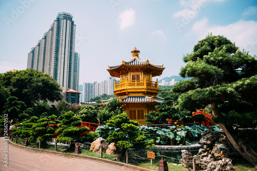 China, Hong Kong, Diamond Hill, Nan Lian Garden, Golden Pavilion of Absolute Perfection surrounded by skyscrapers photo