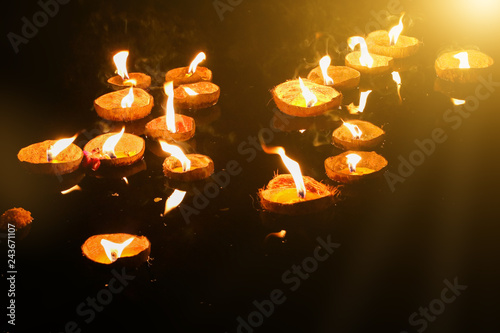 Photography Thai Loy Krathong tradition, made from coconut shell, has a spotlight candle on the water surface with darkness at night and light through