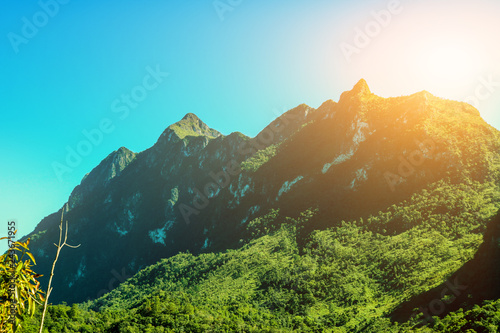Tableau sur toile The large green mountains covered with trees and abundant nature consist of blue skies with sunlight shining through