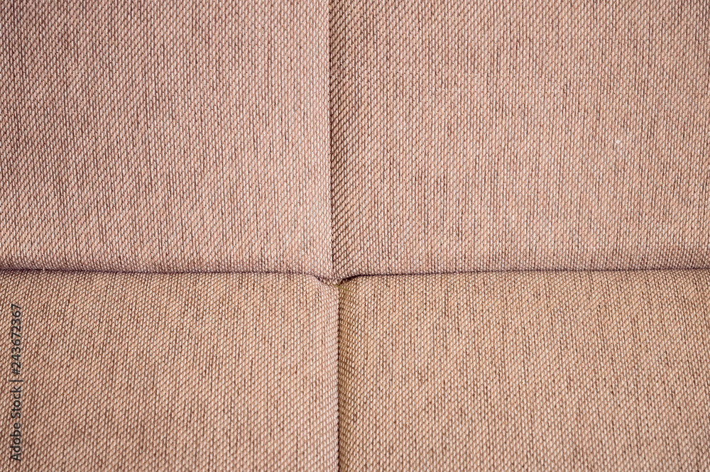 Fototapeta premium A close-up of a fragment of an expensive beige textile sofa in the room