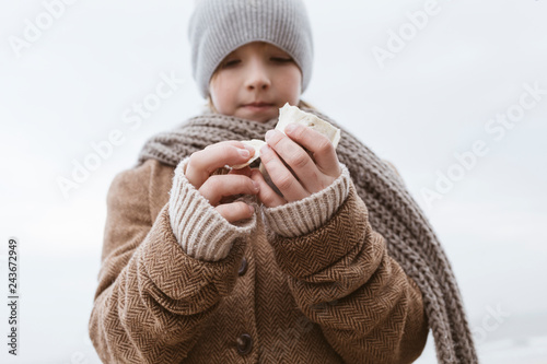 Boy's hands holding cuttlebone on the beach in winter