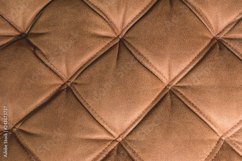 A close-up of a fragment of an expensive brown textile sofa in the room