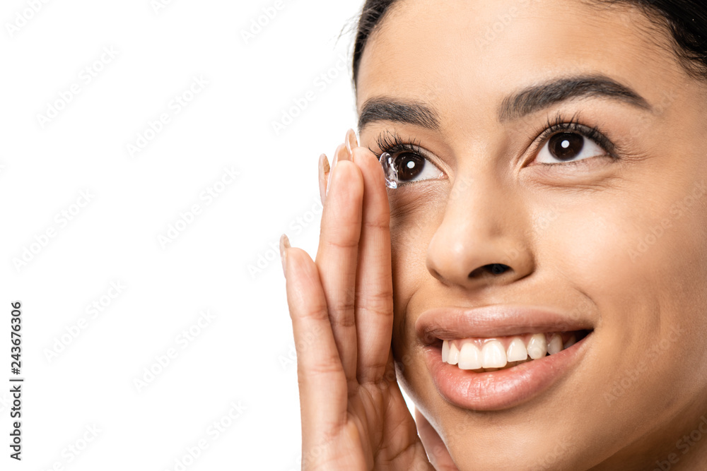 beautiful smiling young african american woman applying contact lens and looking away isolated on white beautiful smiling young african american woman applying contact lens and looking away isolated on white