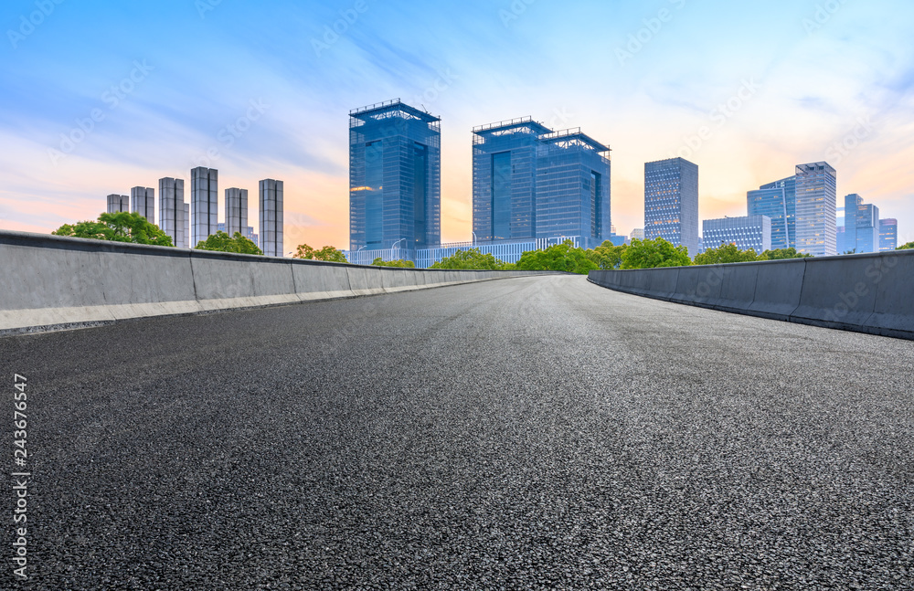 Asphalt road and modern city commercial building in Shanghai at dusk Asphalt road and modern city commercial building in Shanghai at dusk