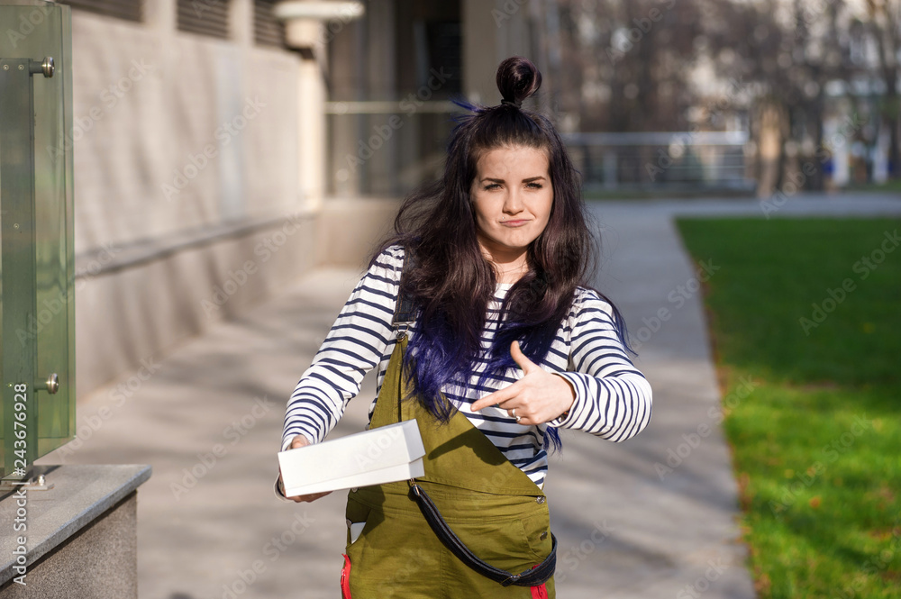 Funny aping girl demonstraiting white box in hands Funny aping girl demonstraiting white box in hands