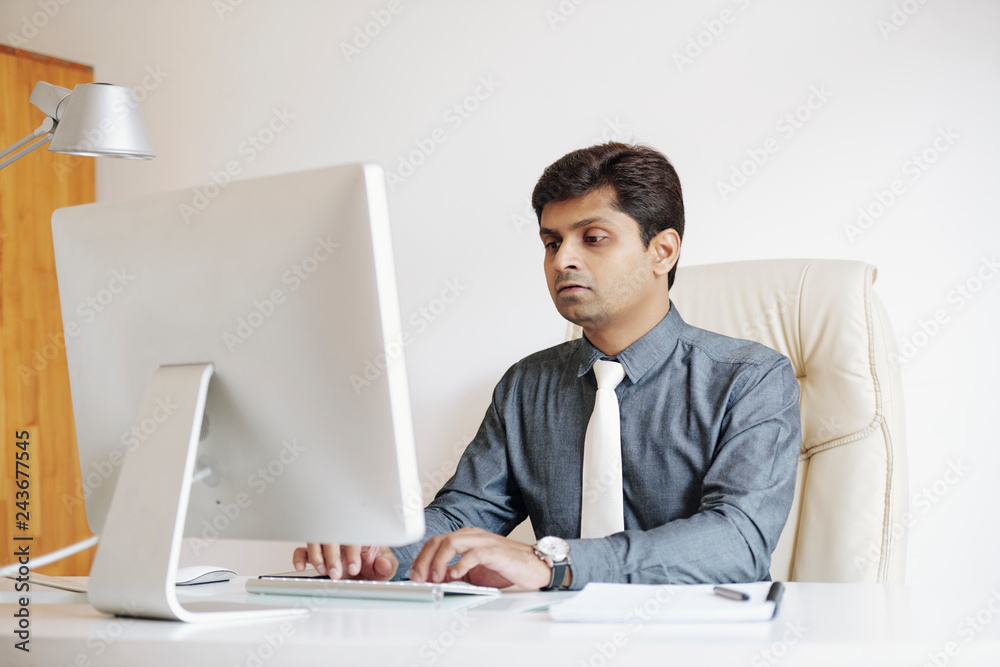 Asian business executive working on computer in his office Asian business executive working on computer in his office