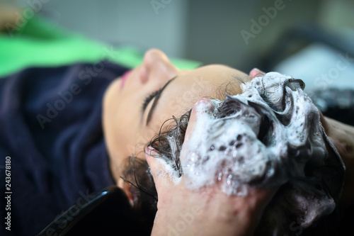 young woman in hairdresser salon washing hair