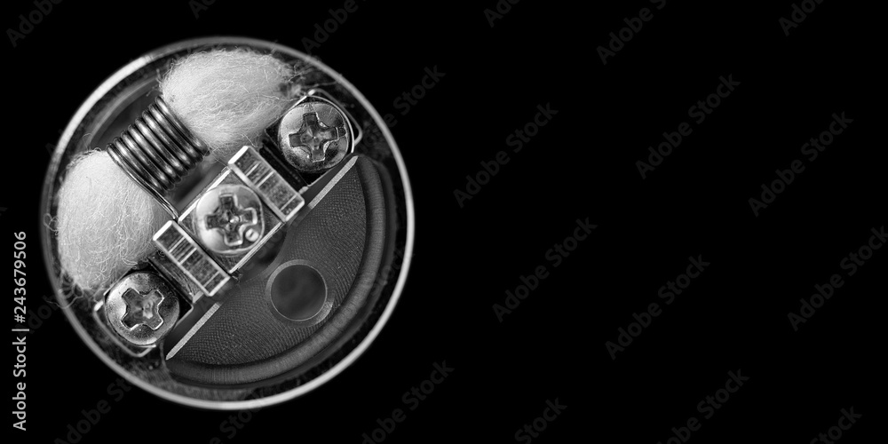 black and white, monochrome shot, top view of single micro coil with  japanese organic cotton wick and single coil reducer in high end  rebuildable dripping atomizer isolated on black background foto de