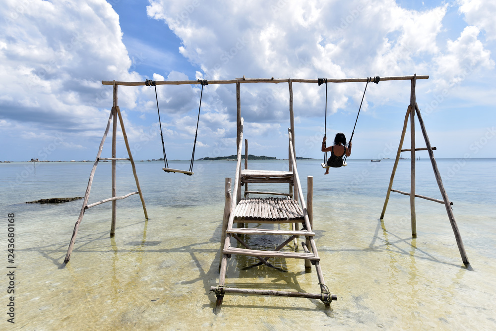 Indonesian girl on a swing at Tanjung Kelayang Beach, Belitung Island, Indonesia Indonesian girl on a swing at Tanjung Kelayang Beach, Belitung Island, Indonesia