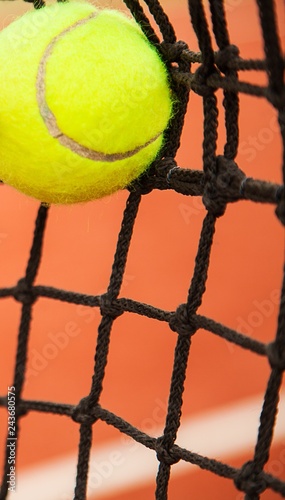 Close up of a tennis ball hitting a net on a tennis court © BillionPhotos.com