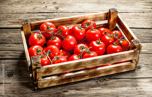 Ripe tomatoes in a wooden box.