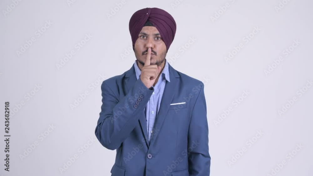 Bearded Indian Sikh businessman with finger on lips Bearded Indian Sikh businessman with finger on lips