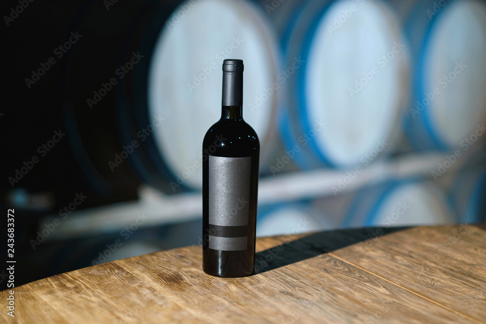 bottle with red wine on wooden table