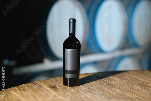 bottle with red wine on wooden table