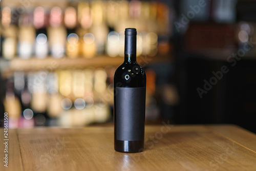bottle with red wine on wooden table